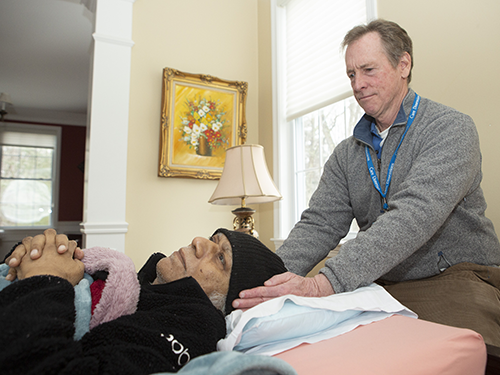 Care Dimensions volunteer Geoff Pope performs reiki on a hospice patient he visits regularly at the patient's home.