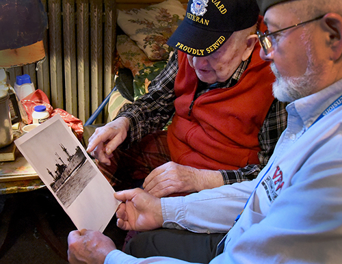 Marvin Spitzer proudly displays medals he earned while serving in the U.S. Coast Guard during WWII. Care Dimensions veteran-to-veteran volunteer Jeff Najarian (right) gave Marvin the medal case and visits him once a week.