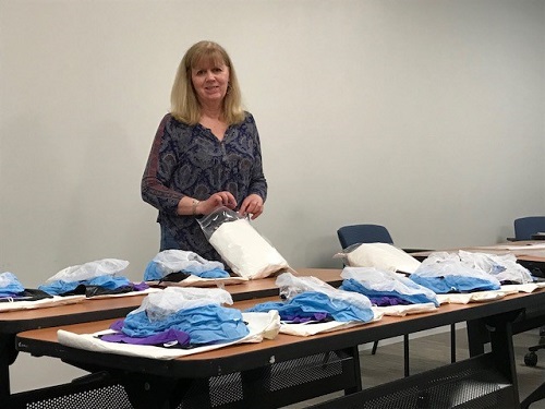 Staff Accountant Ann Amatucci assembles packages of personal protective equipment for Care Dimensions clinical staff members who are seeing hospice patients during the COVID-19 pandemic.