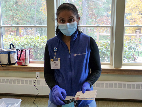 Care Dimensions Director of Pharmacy Services Alifia Waliji-Banglawala demonstrates safe disposal of unused opioids using a medication disposal bag.