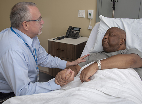 Care Dimensions Associate Medical Director Robert Taylor, MD, FAAHPM, FAAN, meets with a patient at the Care Dimensions Hospice House in Lincoln, MA.