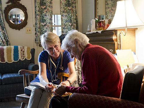 Care Dimensions Admissions Nurse Kitty Cunningham meets with a hospice patient in her home.