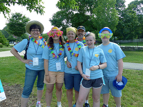 Kelli Ann Sullivan (center) with her family and co-worker Jane Byrne (left) are repeat volunteers at Care Dimensions’ Camp Stepping Stones.