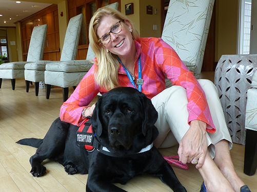 Care Dimensions volunteer Nancy Littlehale relaxes with her pet therapy dog, Poppy, at the Kaplan Family Hospice House in Danvers.