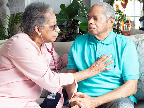 Spanish-speaking hospice nurse Luz Tejeda listens to Ramon Pepin’s heartbeat.