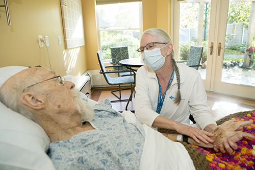 Care Dimensions Massage Therapist Alison Powers visits with a patient at the Kaplan Family Hospice House.