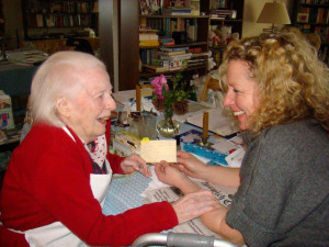 Care Dimensions volunteer laughing with female hospice patient while reviewing recipe card