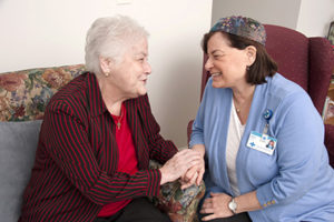 Care Dimensions chaplain Matia Angelou talks with female hospice patient