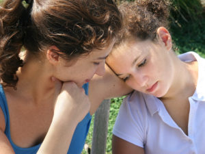 mother helping sad daughter cope with grief
