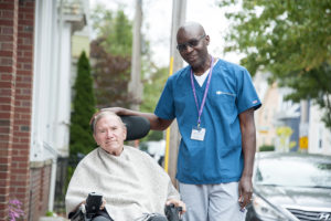John Driscoll enjoys some time outside of his Salem, MA, home with Care Dimensions hospice aide Moses Mugwanya.