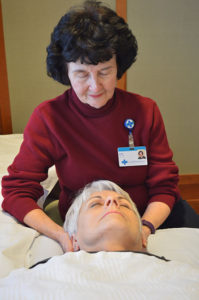 Care Dimensions volunteer Joan Charette gives Reiki to patients at the Kaplan Family Hospice House to help them relax.