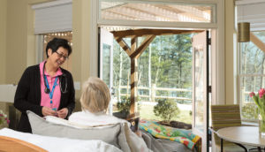 Trudy Miller, RN team leader, speaks with a patient at the Care Dimensions Hospice House in Lincoln, MA.