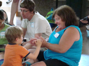 Longtime Care Dimensions volunteer Claire Conway plays with a child attending Camp Stepping Stones.