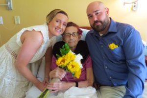 Newlyweds Spencer and Joe Newton sit with Spencer's mother, Margaret, on their wedding day at Care Dimensions' Kaplan Family Hospice House where Margaret was a patient. The couple held the ceremony at the hospice house when Margaret became seriously ill.